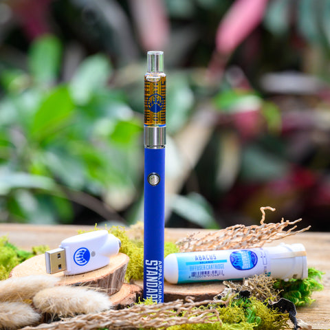 Abacus Vape Kit on wood table with moss and plant in background from Appalachian Standard