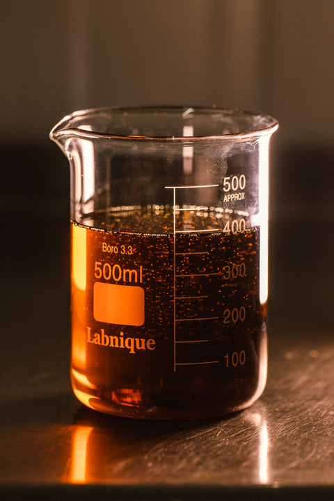 Premium amber cannabis crude oil in 500ml Labnique borosilicate beaker showing high-terpene content from subcritical CO2 extraction process at Asheville NC hemp processing lab - solvent-free extraction producing full-spectrum hemp extracts with superior purity for East Coast manufacturers.