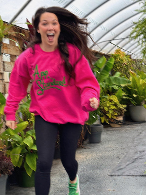 Gracie running through the greenhouse in Asheville, NC wearing her Appalachian Standard pink and green sweatshirt.