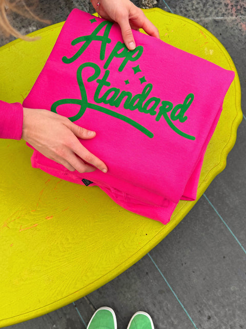 Appalachian Standard's pink and green Spring Break Sweatshirt on a lime green table.