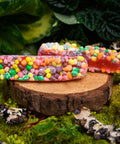 Two pieces of Appalachian Standard's Boujee Ropes CBD Candy on a small wooden platter on a bed of moss