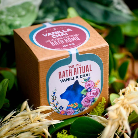 A box of Appalachian Standard's Vanilla Chai CBD Bath Bomb surrounded by plants
