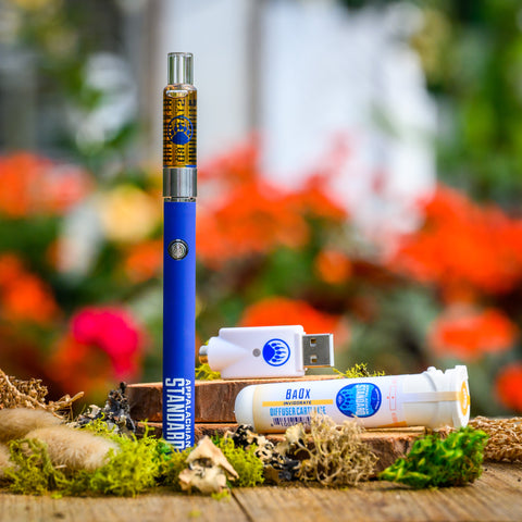 Baox Vape Kit on wood table with moss and plant in background from Appalachian Standard