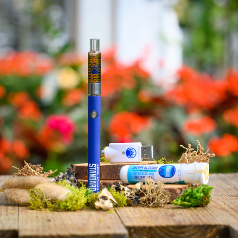 Appalachian Standard's Cherry Blossom CBD Vape Kit on wood table surrounded by moss and plants
