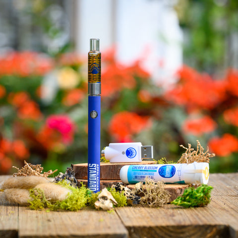 Cherry Blossom Vape Kit on wood table with moss and plant in background from Appalachian Standard
