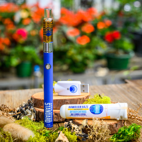 Appalachian Standard's Hawaiian Haze CBD Vape Kit on wood table surrounded by moss and plants