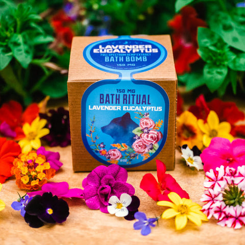 Lavender Eucalyptus Bath Bomb in packaging surrounded by plants and flowers from Appalachian Standard