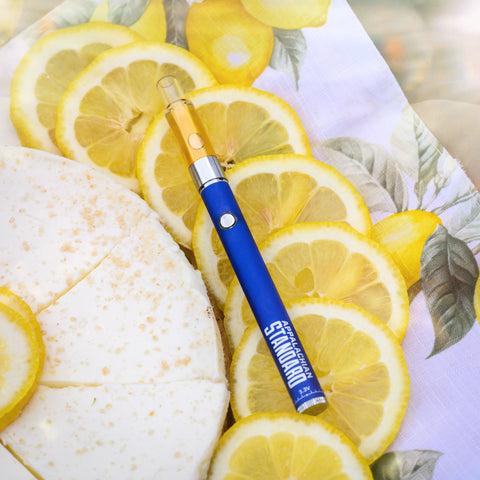 Lemon Cheesecake Vape on top of lemons next to a cheesecake by Appalachian Standard