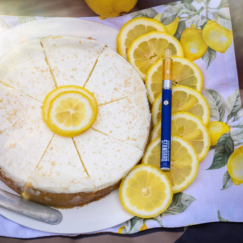 Lemon Cheesecake Vape on top of lemons next to a cheesecake by Appalachian Standard