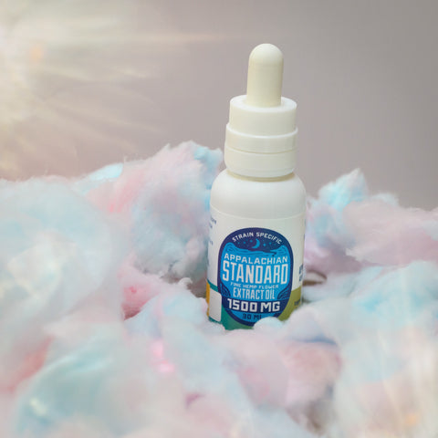 A 30 ml tincture bottle of Appalachian Standard's Cotton Candy CBD Tincture on a bed of cotton candy