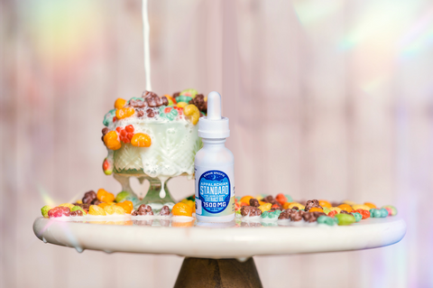 A bottle of Appalachian Standard's Tutti Frutti CBD Tincture on a tray surrounded by Trix cereal