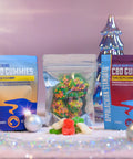 A photo of Appalachian Standards Yuletide Yummy Gummies featuring Limited Edition Christmas Boujee Bears and Boujee Bites, paired with their best-selling Classic Boujee Bears and Elderberry CBD Gummies. The Gummies are surrounded by shiny glass Christmas trees, disco balls, and ornaments.