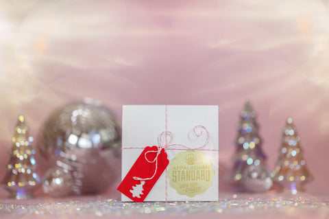 A photo of Appalachian Standards Mrs. Clauses Spa-La-La-La-La packaged in a beautiful white box with candy cane pink ribbon, topped with a red tag.