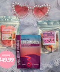 Three bags of candy on a white lace fabric with pink heart shaped sunglasses