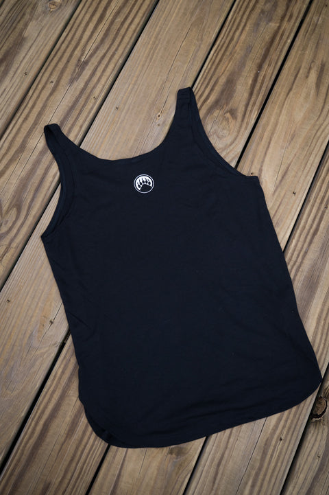 Black tank top with a white logo on a wooden surface