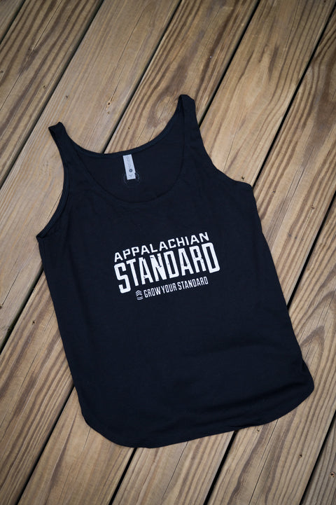 Black tank top with 'Appalachian Standard' text on a wooden surface