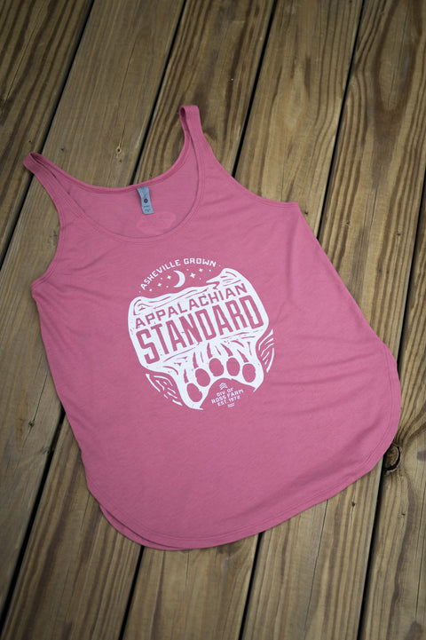 Pink tank top with white graphic design on a wooden surface