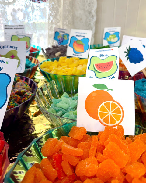 Colorful candy display with fruit-themed cards in the background