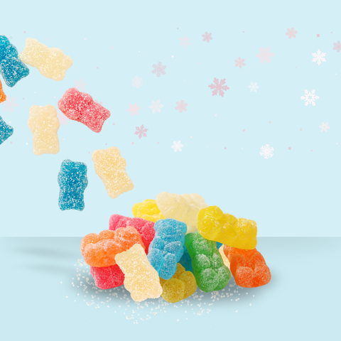 Colorful gummy bears on a light blue background with snowflake decorations