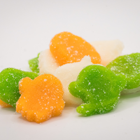 Colorful CBD Ghoulish Gummies shaped like ghosts and pumpkins on a white background.