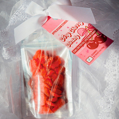 Clear bag with red gummy bears and a pink label on a white lace background