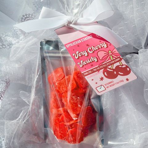 Red candy in a clear bag with a pink label on a white textured background