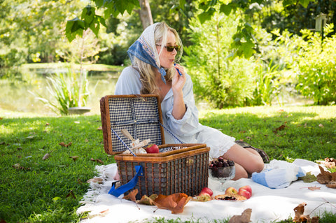 Woman having a picnic in a park with a basket and food items for Appalachian Standard's High Country Hunny Fall CBD launch.