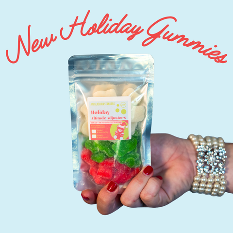 Hand holding a package of holiday-themed gummies with text 'New Holiday Gummies' on a light blue background.