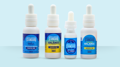 Appalachian Standard's CBD tincture lined up with four bottles in a row and a blue background.