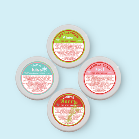 Four containers of Appalachian Standard CBD body cream with colorful labels on a light blue background