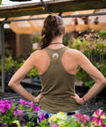 Person wearing a green tank top with a paw print design in a garden setting