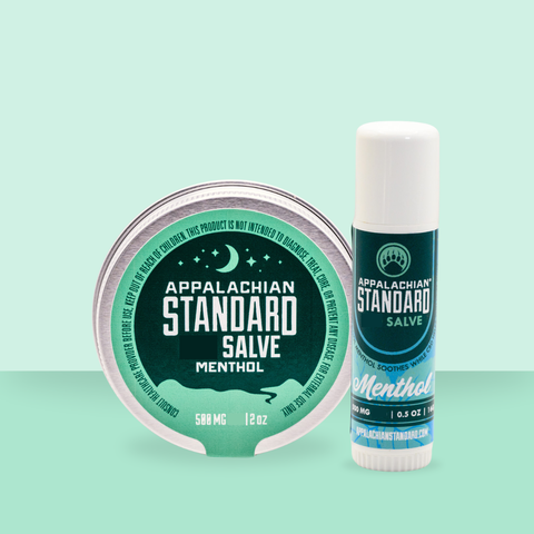 Appalachian Standard's Menthol Salve Tin and Salve Stick with blue/green labels on a green background.