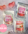 Three bags of candy on a white lace fabric with pink heart shaped sunglasses