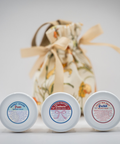 Three containers of Appalachian Standard CBD body cream with labels in front of a decorative bag on a light background.