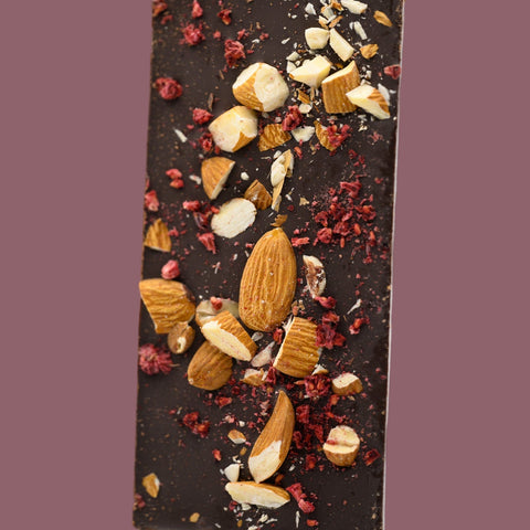 Appalachian Standard's dark chocolate bar with nuts and dried fruits on a pink background