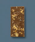 Appalachian Standard Salted Croissant THC Chocolate bar with gold flakes on a blue background.