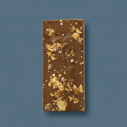 Appalachian Standard Salted Croissant THC Chocolate bar with gold flakes on a blue background.