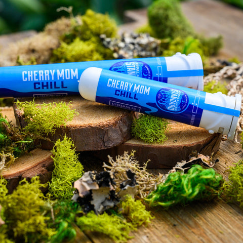 Cherry Mom Pre-rolls in Sana packaging on a wood and moss display from Appalachian Standard.
