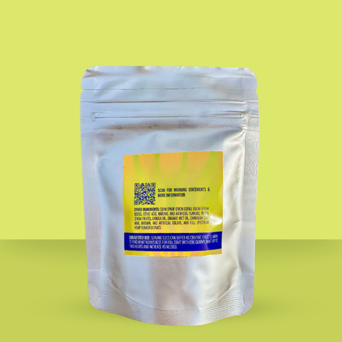 Back of Appalachian Standard CBD Gummies resealable silver mylar pouch against a lime green background. The label includes a QR code for warning statements, an ingredients list featuring corn syrup, sugar, citric acid, natural and artificial flavors, pectin, canola oil, organic MCT oil, carnauba leaf wax, and full spectrum hemp flower extract. Suggested use instructions advise starting with one gummy and waiting up to two hours before increasing dosage.