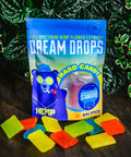 A bag of Appalachian Standard's Dream Drops CBD Hard Candy and 11 pieces of CBD hard candy with plants in background