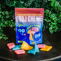 A bag and pieces of Appalachian Standard's Bouj Chews CBD Taffy Candy with plants in the background
