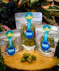 Kush Cake flower in three sizes on a wooden platter with plants in the background grown and packaged by Appalachian Standard