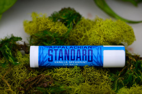 A stick of Appalachian Standard's Vanilla Spearmint Lip Balm on a bed of moss