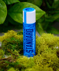 A stick of Appalachian Standard's Vanilla Spearmint Lip Balm on a bed of moss