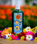 A bottle of Appalachian Standard's Main Squeeze Hemp Lotion on a piece of wood surrounded by flowers