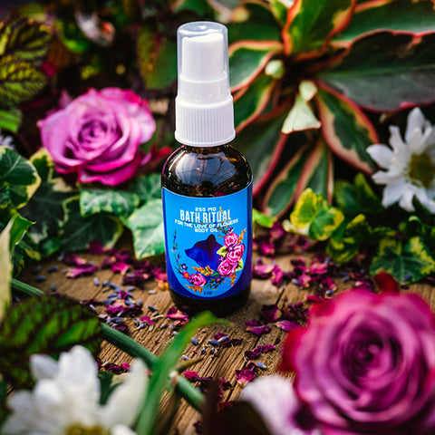 For the Love of Flowers Hemp Body Oil on a wooden table surrounded by roses and lavender from Appalachian Standard Hemp