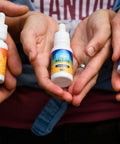 Three pairs of hands cupped holding 1 oz bottles of Appalachian Standard's tinctures from the CBD Tincture Trio