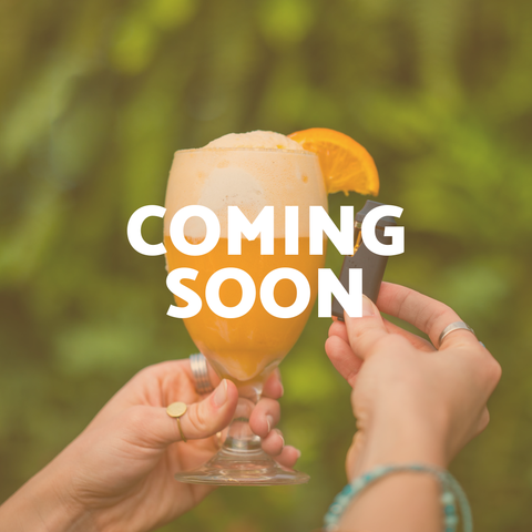 Two hands hold an Appalachian Standard vape pen and an orange cream soda float in a stemmed glass garnished with an orange slice, against a soft green outdoor background. Bold white text reads "COMING SOON.