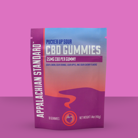 A package of Appalachian Standard Pucker Up Sour CBD Gummies. The packaging is pink and purple with text detailing the flavor and CBD content.