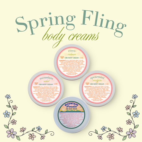 Four body cream containers with labels on a light background, labeled 'Spring Fling body creams'.